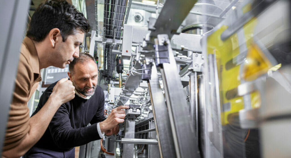Picture of two men looking at a packaging maschine