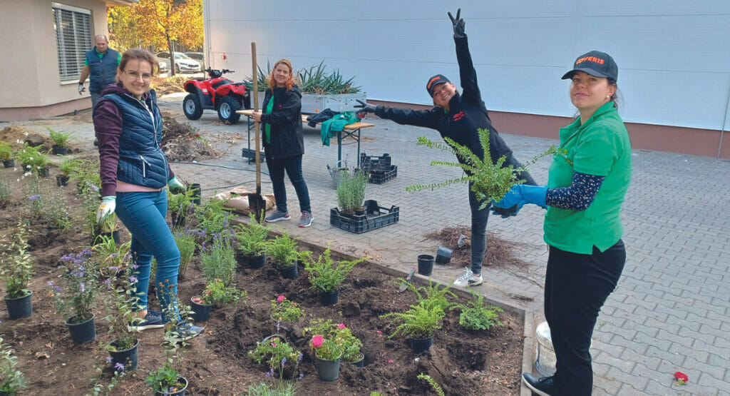 Bild von Mitarbeitern bei Coveris an einem Blumenbeet