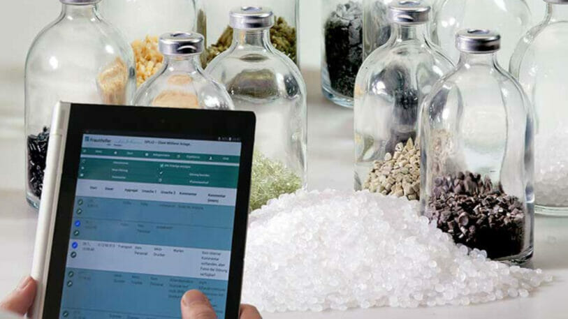 Bild von einem Tisch mit Rezyklat, medizinischen Flaschen und einem Tablet mit Daten