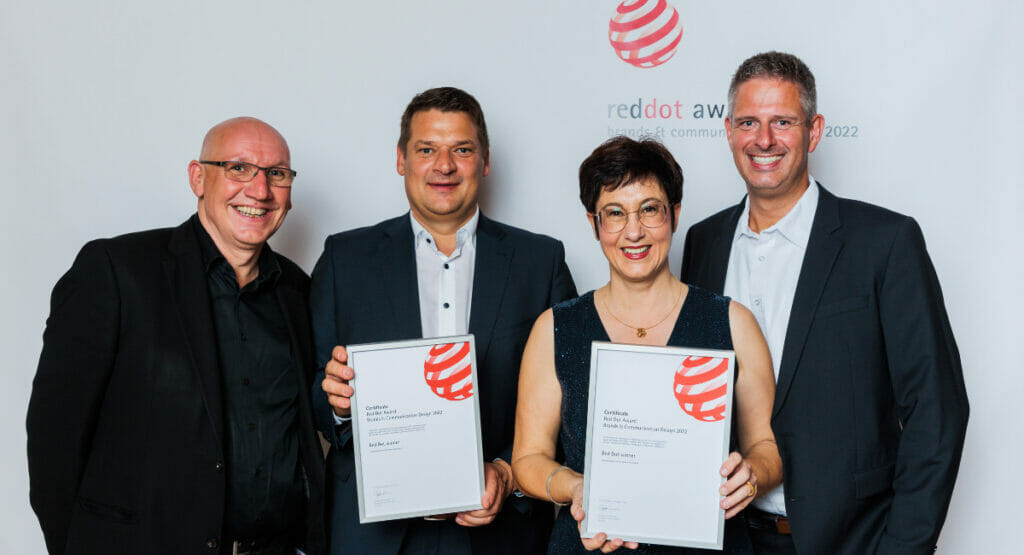 Picture of two men and a woman with a certificate