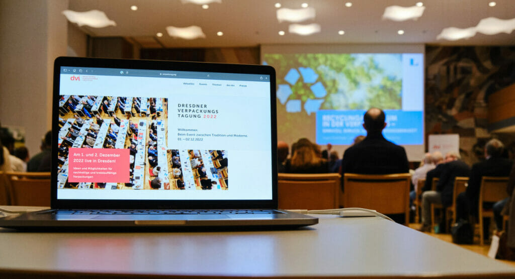Auf einem Laptop ist das Titelbild der Dresdner Verpackungstagung zu sehen.