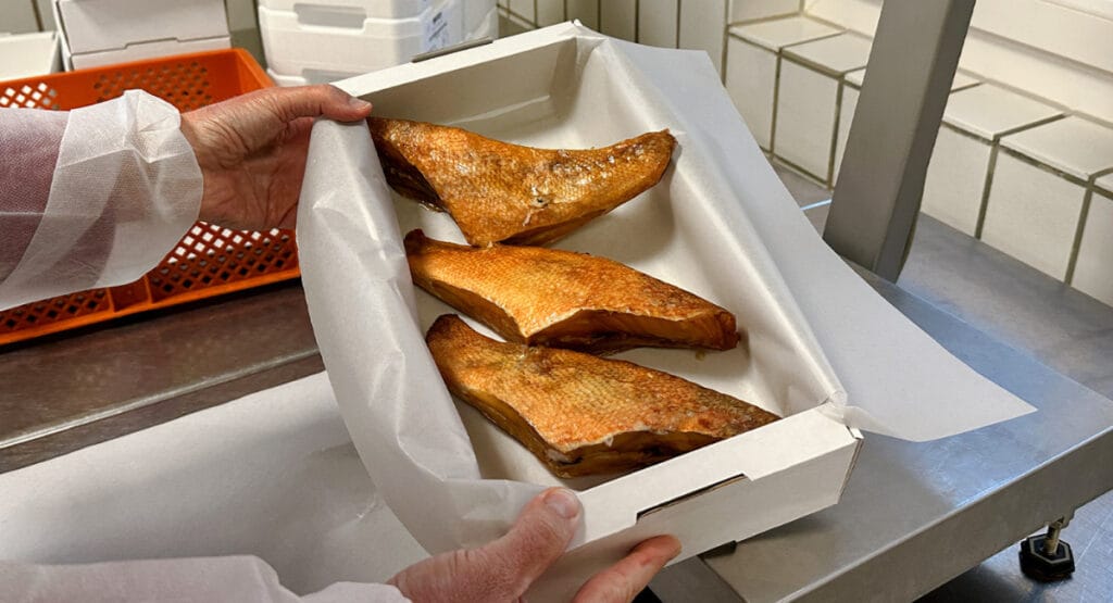 Wellpappe, Wachstuch und wasserbasierter Barrierelack - daraus besteht die neue Verpackung für Räucherlachs von der STI Group